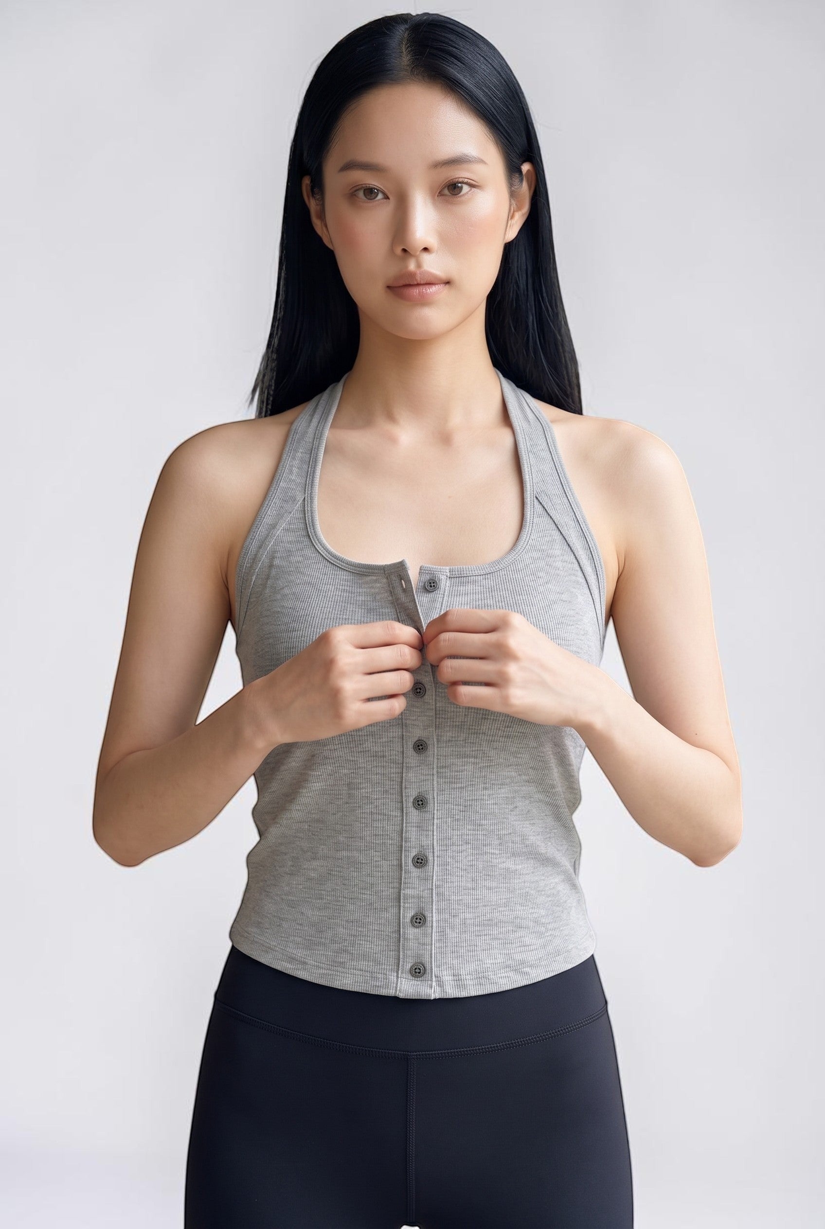SOLAのグレーのリブ素材フロントボタン付きUラインホルターネックブラトップを着用した女性