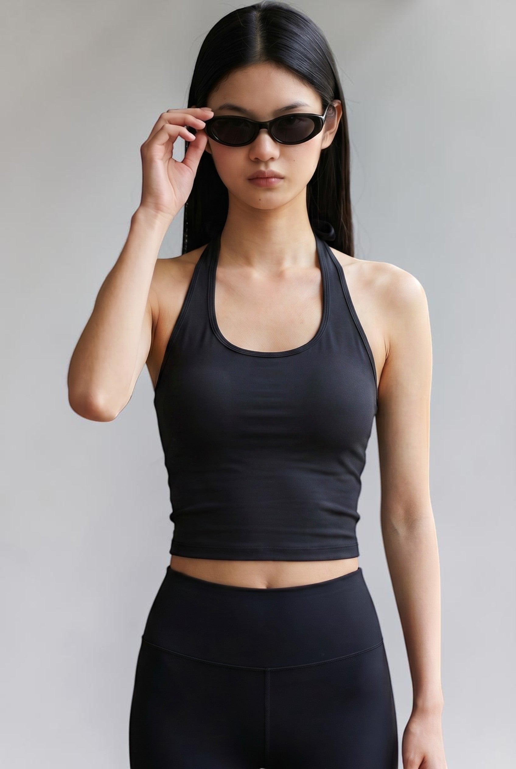 SOLAの黒いホルターネックブラトップを着用しサングラスをかけた女性