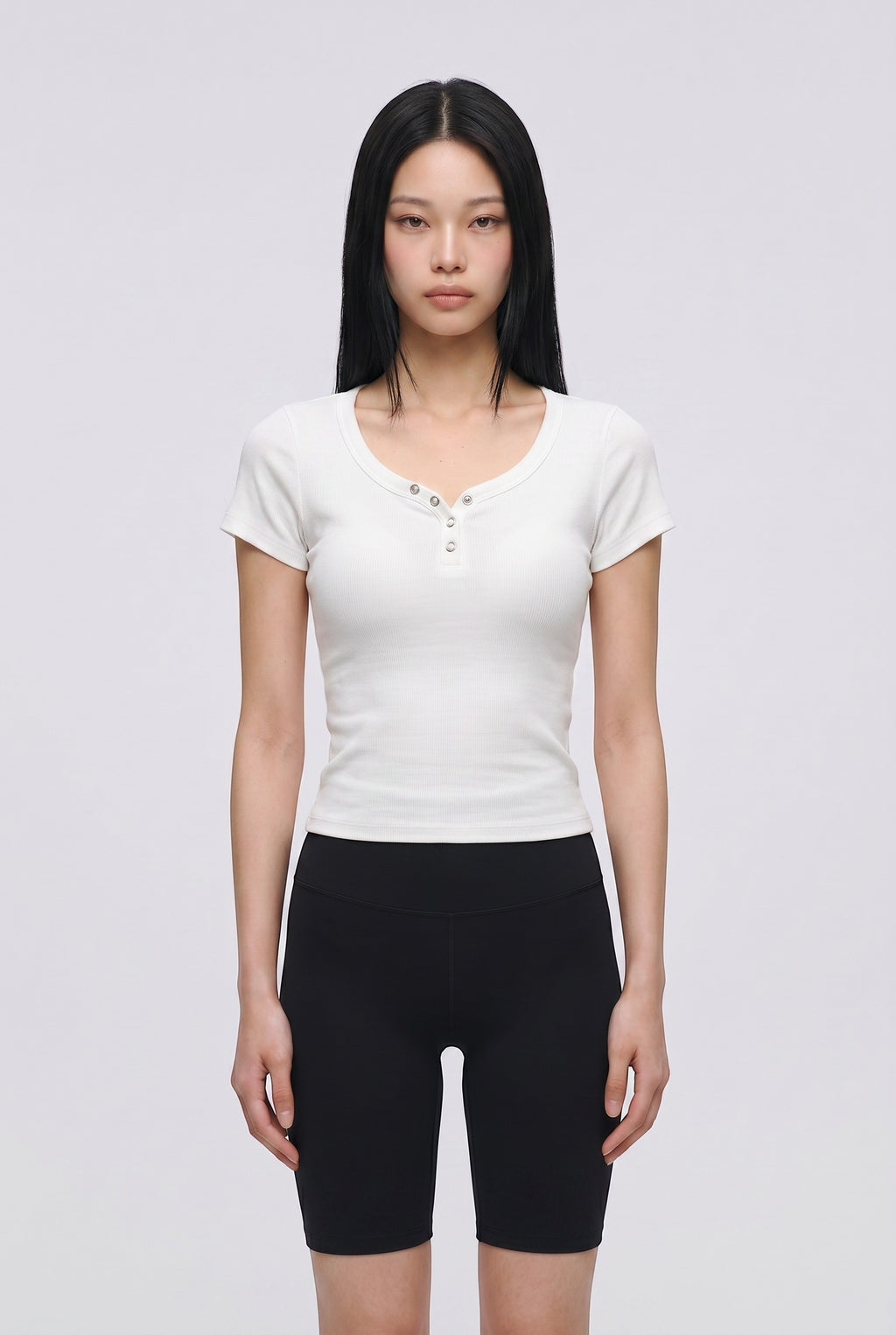 SOLAのトリプルボタン付きホワイトリブブラトップTシャツを着用したモデル