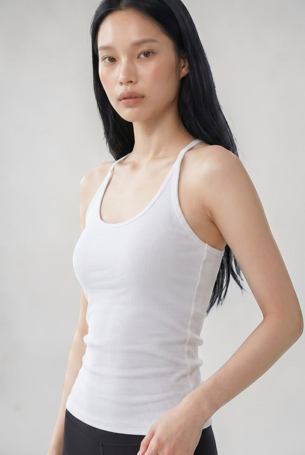 SOLAのホワイトのコットンリブ素材を使用したUラインキャミソールブラトップを着用した女性