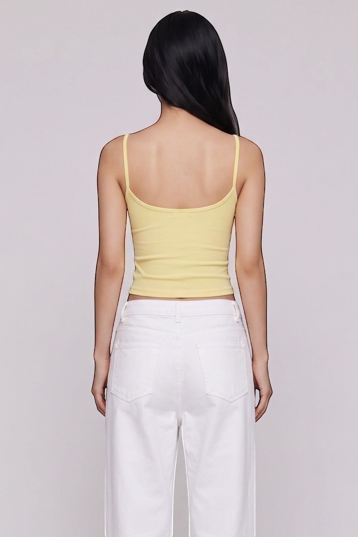 SOLAのイエローのキャミソールを着用し、白いワイドパンツを合わせた後ろ姿の女性